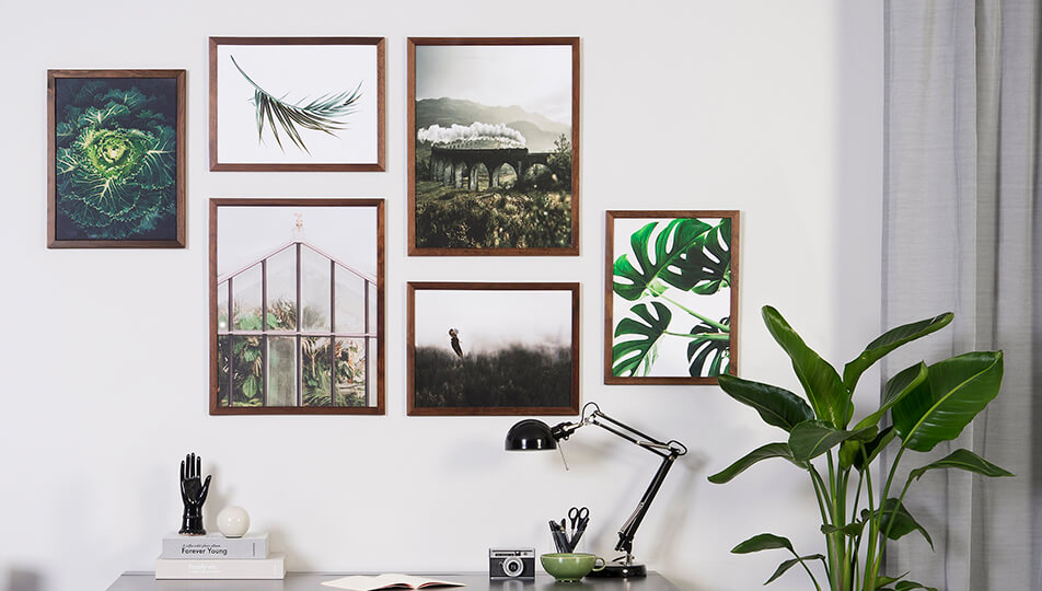 Posterwand op kantoor - donkere houten fotolijsten en groene natuurmotieven